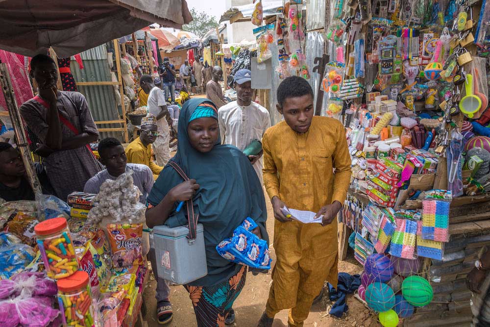 A vaccinator team in a market during a polio immunization campaign in Kano State. © Andrew Esiebo/WHO