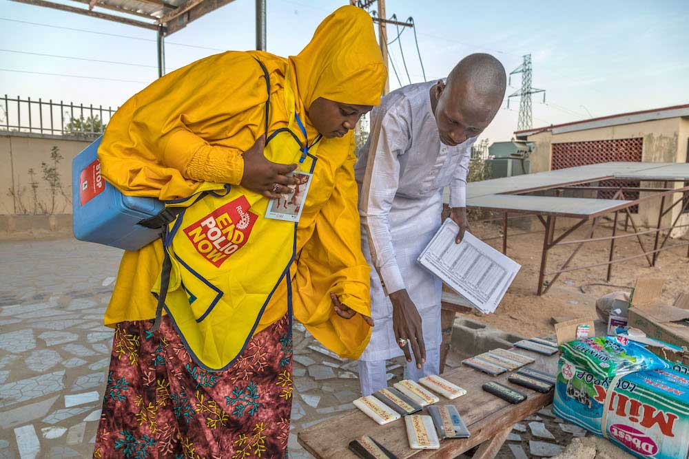 A vaccinator in Maiduguri collects materials for a door-to-door polio vaccination campaign, including vaccine box, recording sheet, mobile phone and marking pen. © Andrew Esiebo/WHO