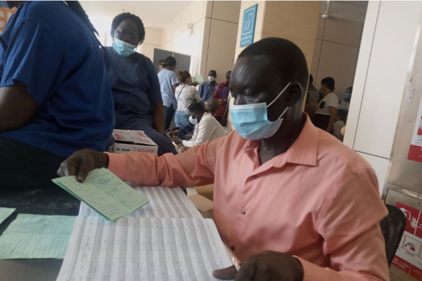 A healthcare worker at Juba Teaching Hospital crosschecks  vaccination details in a card