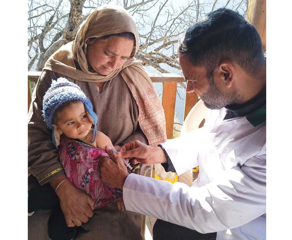 Ahmad administers routine immunisation to a child in Naga village.