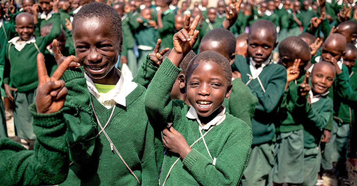 children holding up peace signs and smiling