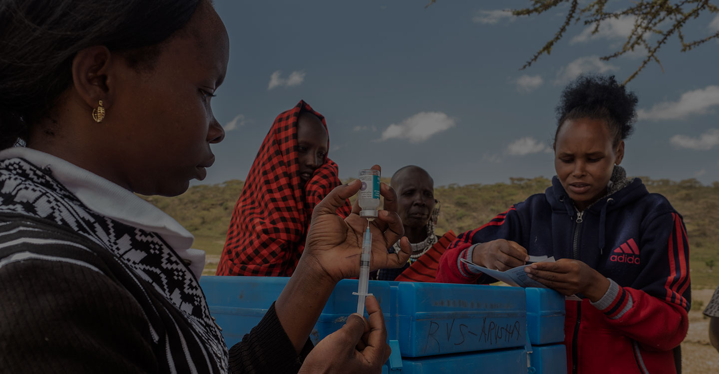 health worker preparing vaccine for maasai