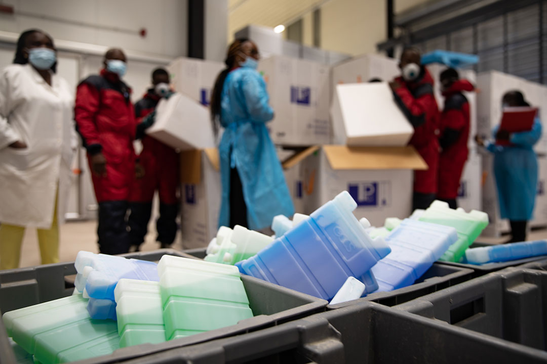 Le personnel de la chaîne du froid déballe les vaccins COVID-19 pour le stockage dans la chambre froide. Entrepôt de stockage de vaccins, commune de Kinkole, Kinshasa, RDC. – Crédit: Desjardins Sibylle
