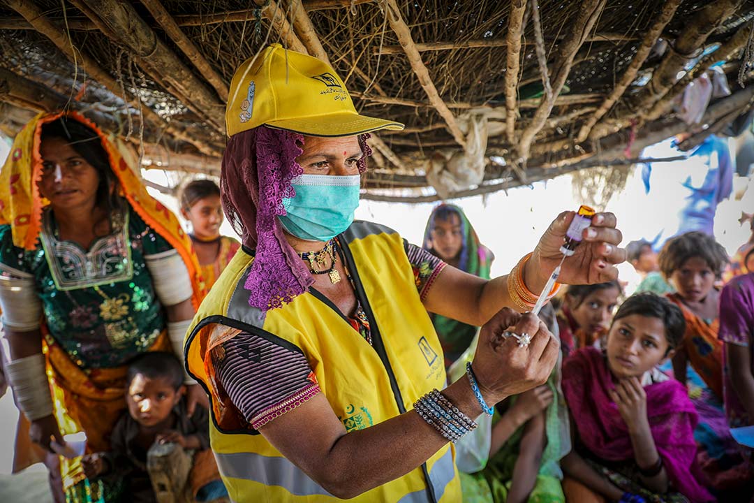 Deli Bai, a Lady Health Worker (LHW), prepares measles-rubella (MR) vaccine for a girl during the nationwide MR vaccination campaign in Sindh province, Pakistan. Gavi/2021/Asad Zaidi
