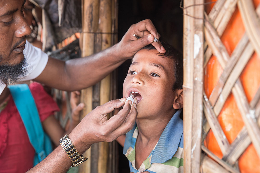 Community health worker Hafzur Rahman gives a young boy the oral cholera vaccine during a door-to-door vaccination session in Camp 4, Kutupalong. Gavi/2019/Isaac Griberg