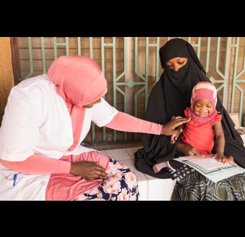 A baby plays with their mother and a health worker at CSI Nouveau Marché, a health centre in Niamey, Niger. Credit: Isaac Griberg