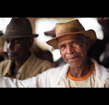 Gavi/2016/Randrianarivony Voara - An older man smiles at the camera during the visit to the CSBII Tsianofana of Vaingandrano health centre by Gavi CEO Dr Seth Berkley. A DPEV, WHO and UNICEF Representative were also present