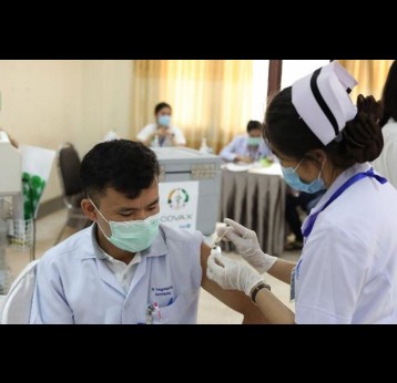 A health worker receives a dose of Pfizer vaccine received through COVAX