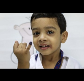 A boy proudly shows the ink mark on the tip of his finger. He was vaccinated against typhoid during the campaign in Sindh province in November 2019. PATH/Asad Zaidi