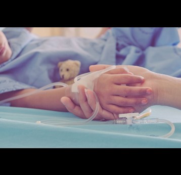 Mother holding child's hand who fever patients in hospital to give encouragement.