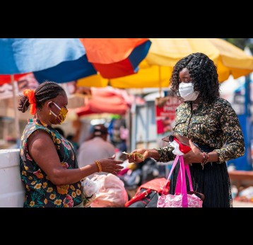 Two women wearing locally made mask and surgical mask on the street in COVID-19 pandemic season for protection.
