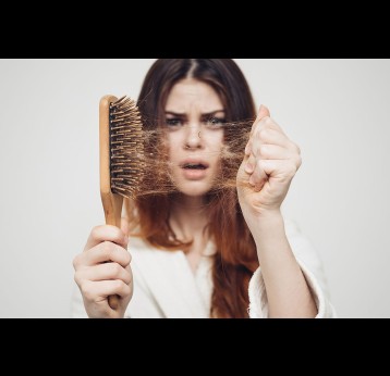 Woman holding a brush and problem hair.
