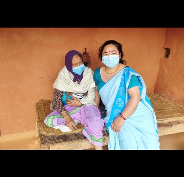 Lila Thapa (right), a female community health worker, with Devi Kali Tandan after she was taken to her home from Gaudakot health post.