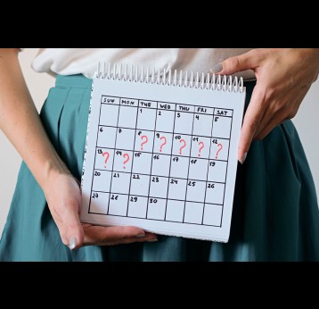 Woman holding calender with marked missed period.
