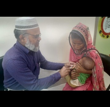 Medical Technologist Mujibar Rahman administering EPI vaccines to Tanha Akter, daughter of Aklima, at a vaccination centre at the EPI Headquarters in Mohakhali, Dhaka. Credit: Mohammad Al Amin