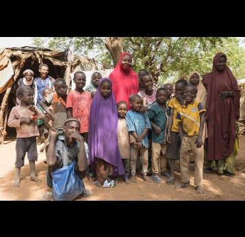 Rachida Moussa (in red), a community health worker in Niamey, Niger, pictured with children living in one of the communities she visits regularly. Credit: Isaac Griberg