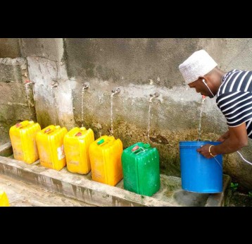 A resident of Kijangwani in Zanzibar fetches clean water from public taps  for home use. Credit: Syriacus Buguzi