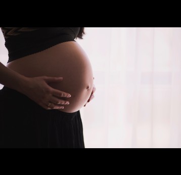 Pregnant woman with her hands on her belly. Credit: freestocks on Unsplash