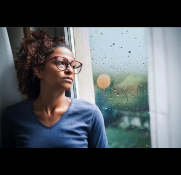 Woman looking out a window. Credit: tommaso79/Shutterstock