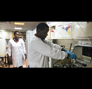 Fredric Nganga places the samples in a shaker, under the watchful eyes of Dr. Florence Mutua. Credit: Claudia Lacave/Hans Lucas