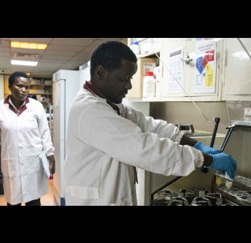 Fredric Nganga places the samples in a shaker, under the watchful eyes of Dr Florence Mutua. Credit: Claudia Lacave/Hans Lucas
