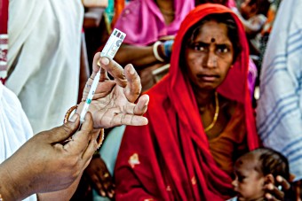 A nurse prepares the pentavalent vaccine at a rural health clinic in India. 