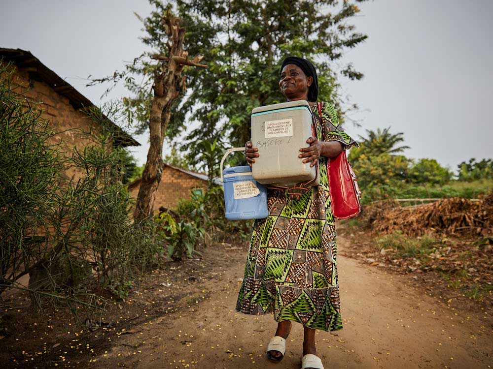Health worker Apuma Matungulu visits villages in Bandundu on foot with her cooler box of polio vaccines to vaccinate children. © Hugh Cunningham