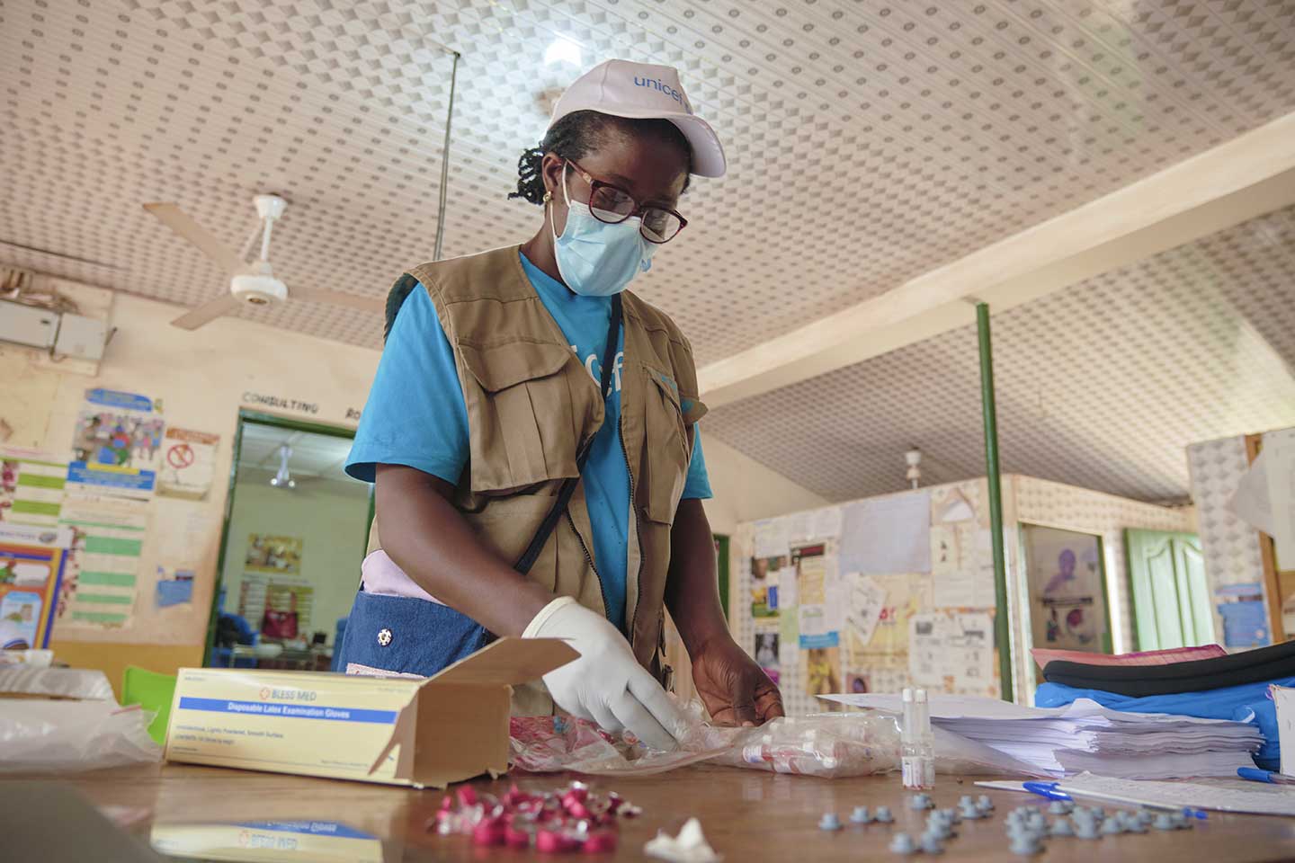 Josephine Agborson, agent de santé à l'UNICEF, inspecte les flacons de vaccins au centre sanitaire de Berekuso, dans la région de l'Est, le 10 octobre 2020. ©UNICEF/ANNANKRA