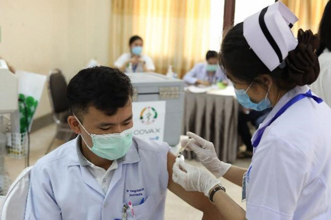 A health worker receives a dose of Pfizer vaccine received through COVAX