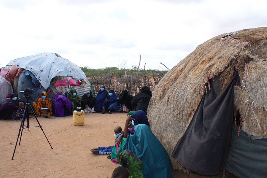 Atheley, comté de Garissa : des femmes attendent que les deux influenceuses de médias sociaux leur donnent des informations sur la vaccination contre la COVID-19 et enregistrent leur vidéo TikTok.