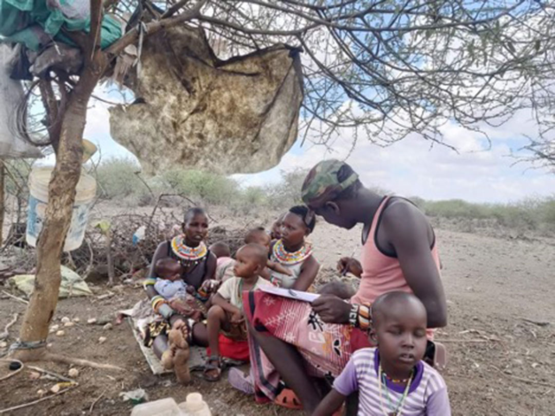 A volunteer, Jeisen Lebasha, educates families in Marti Village, Samburu County, on the importance of receiving the jab