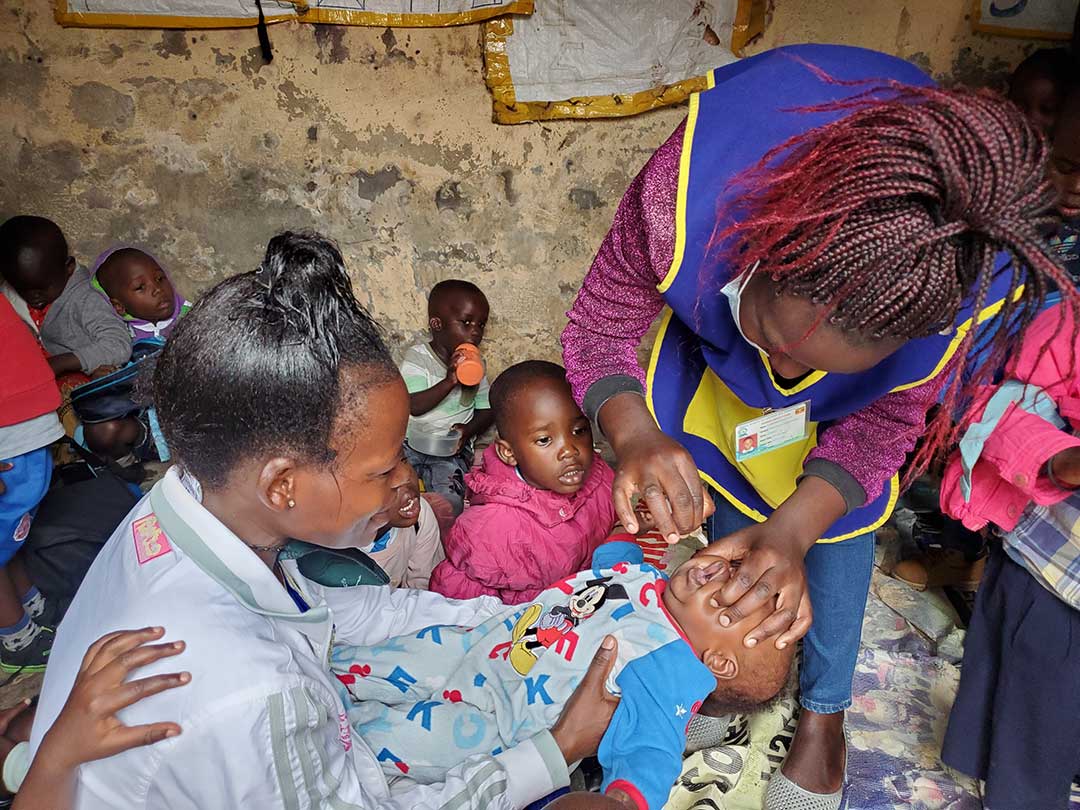Robina Kemigisha, a teacher at Umi Zaituni Nursery school has her child vaccinated against polio. Health workers have been moving from door-to-door, including in schools, to vaccinate all children under the age of five against the vaccine-derived polio type 2.