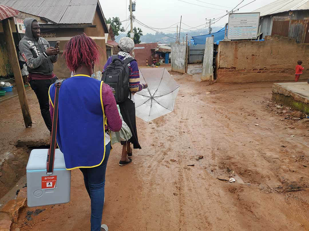 Health worker, Juliet Acamango and Village Health Team member Florence Nakalema walk through the informal settlements of Kisugu as they carry out door-to-door vaccination against polio for all children under the age of five. This is part of a nationwide vaccination campaign.