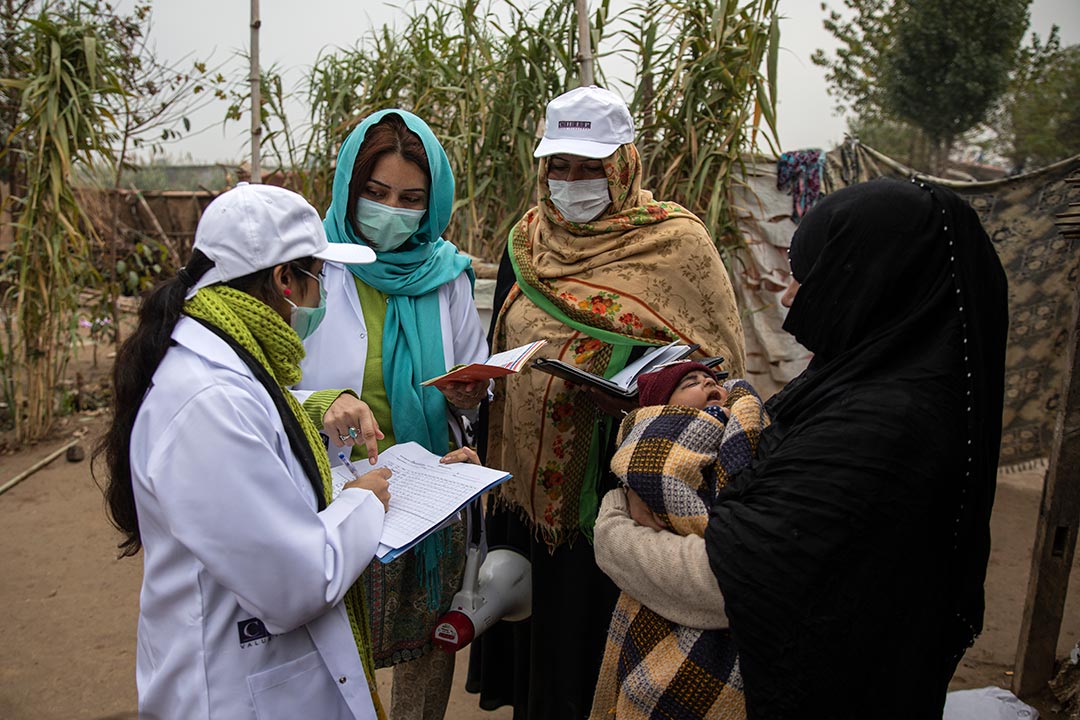 Community Engagement Officer, Sadaf Fareed, with her team checking the vaccination record cards during their field work in a slum in Islamabad. Credit: Gavi/Pakistan/Asad Zaidi