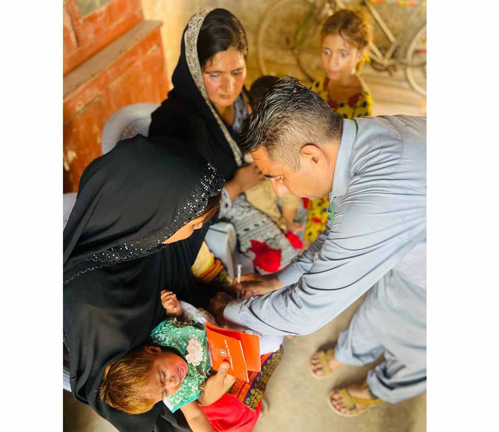 Muhammad Kamran vaccinating a child at an outreach site