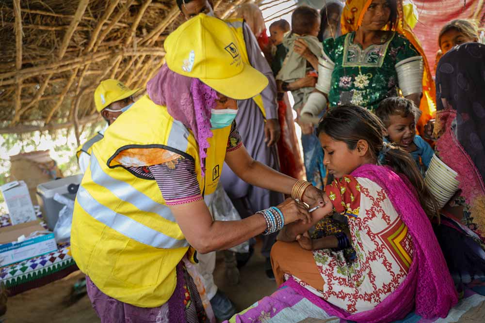 Deli Bai, a LHW (Lady Health worker) administers a measles and rubella injection to a young girl during the nationwide MR campaign in Marno Vena village, District Tharparkar. Sindh province, Pakistan. Credit: Gavi/2021/Asad Zaidi