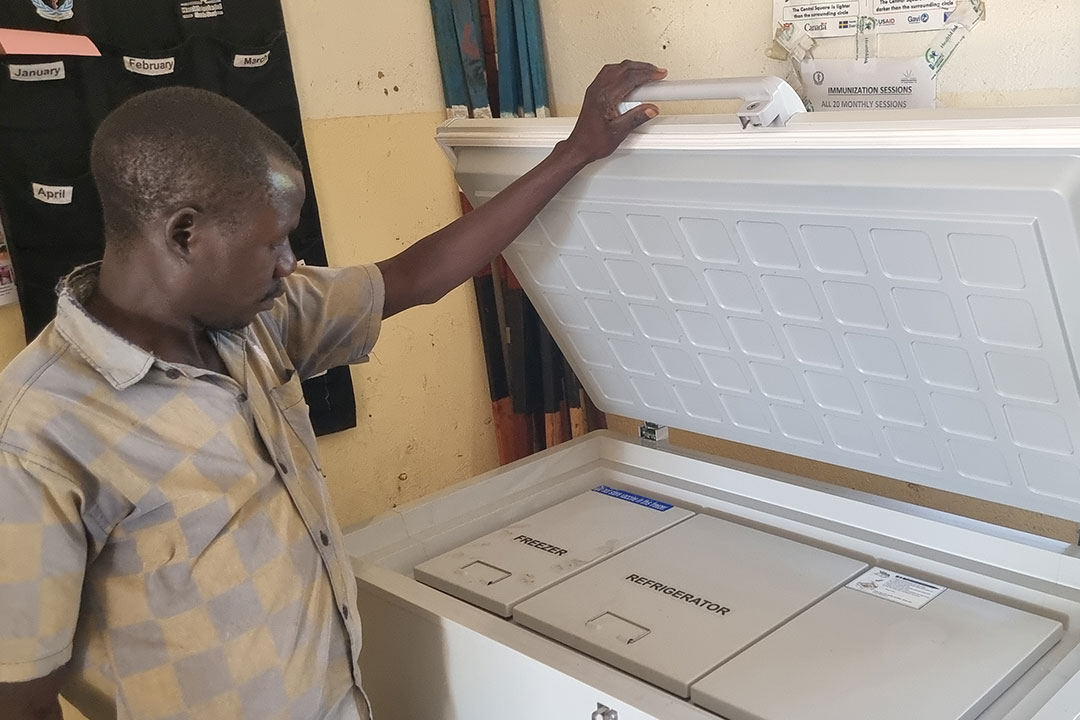 Vaccinator Alex Onek James checks the solar fridge. Credit: Winnie Cirino