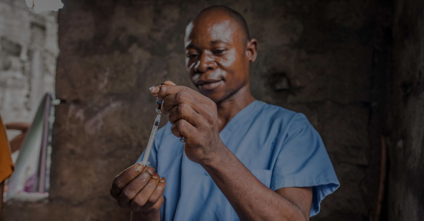 male health worker with vaccine and vial