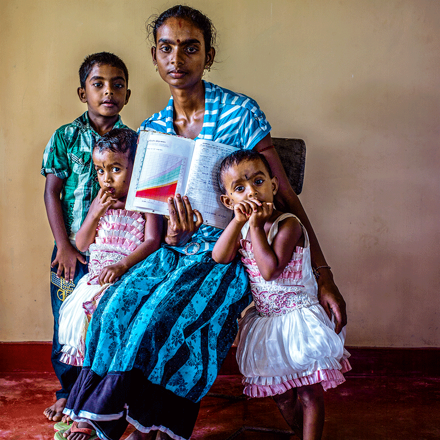 A mother holds up her children’s immunisation cards. Photo: Gavi/Mithra Weerakone.
