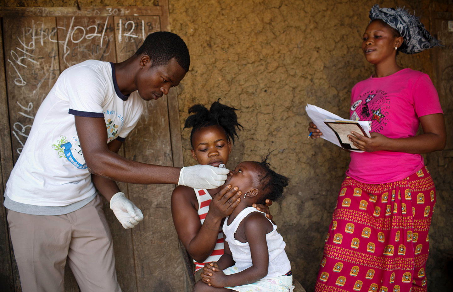 A health worker administers an oral polio vaccination dose to a child in the Kenema District of Sierra Leone. Credit: Gavi/2016/Kate Holt.