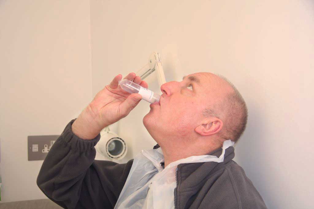 Photo: A study participant intentionally drinking typhoid (Credit: University of Oxford)