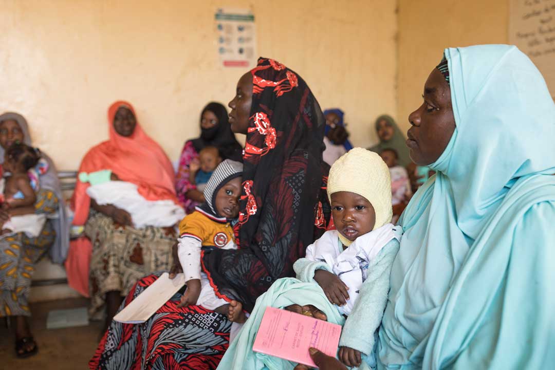Mothers wait with their children to receive a first dose of diphtheria, tetanus and pertussis-containing vaccine. Credit: Gavi/2022/Isaac Griberg