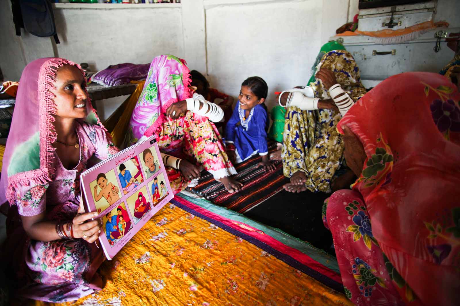  Bai conducts a health education session for village women. As she shows them a book of illustrations, she exhorts mothers to take their babies to the health centre six times within the first 15 months of birth. These six visits, she says, will protect every child from nine dangerous illnesses.