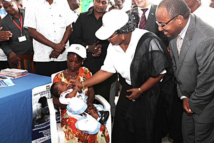 Salma Kikwete, First Lady of Tanzania, administers the first dose of rotavirus vaccines to a Tanzanian baby, as Dr. Hussein Ali Mwinyi, Minister of Health and Social Welfare watches.