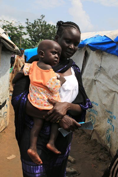Despite the fighting, Vaccine Alliance partners are continuing routine vaccinations here at the Tomping Camp. Mrs Nyalen carries her 11-month-old son Gisma Stephen to a nearby makeshift health clinic for his measles immunisation.