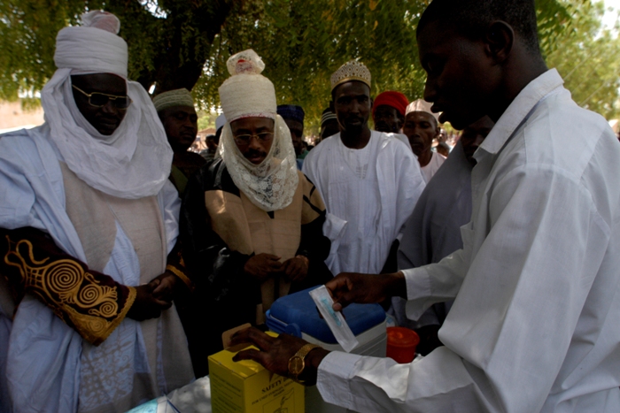 At an Immunisation Day Plus held at the fixed immunisation post in Isawa village, Muhammed Sabo Abdulkadir, the district head of Giade (right) and Yaya Abubakar, the village head of Isawa (left), are seen by members of the community to be endorsing vaccination.