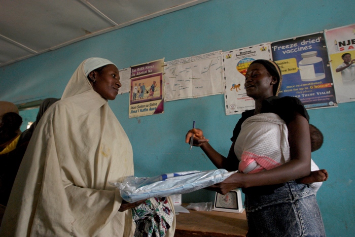 As a reward for fully immunising her child, each mother receives a treated bednet to protect her family against malaria, once she has completed her yellow vaccination card. 