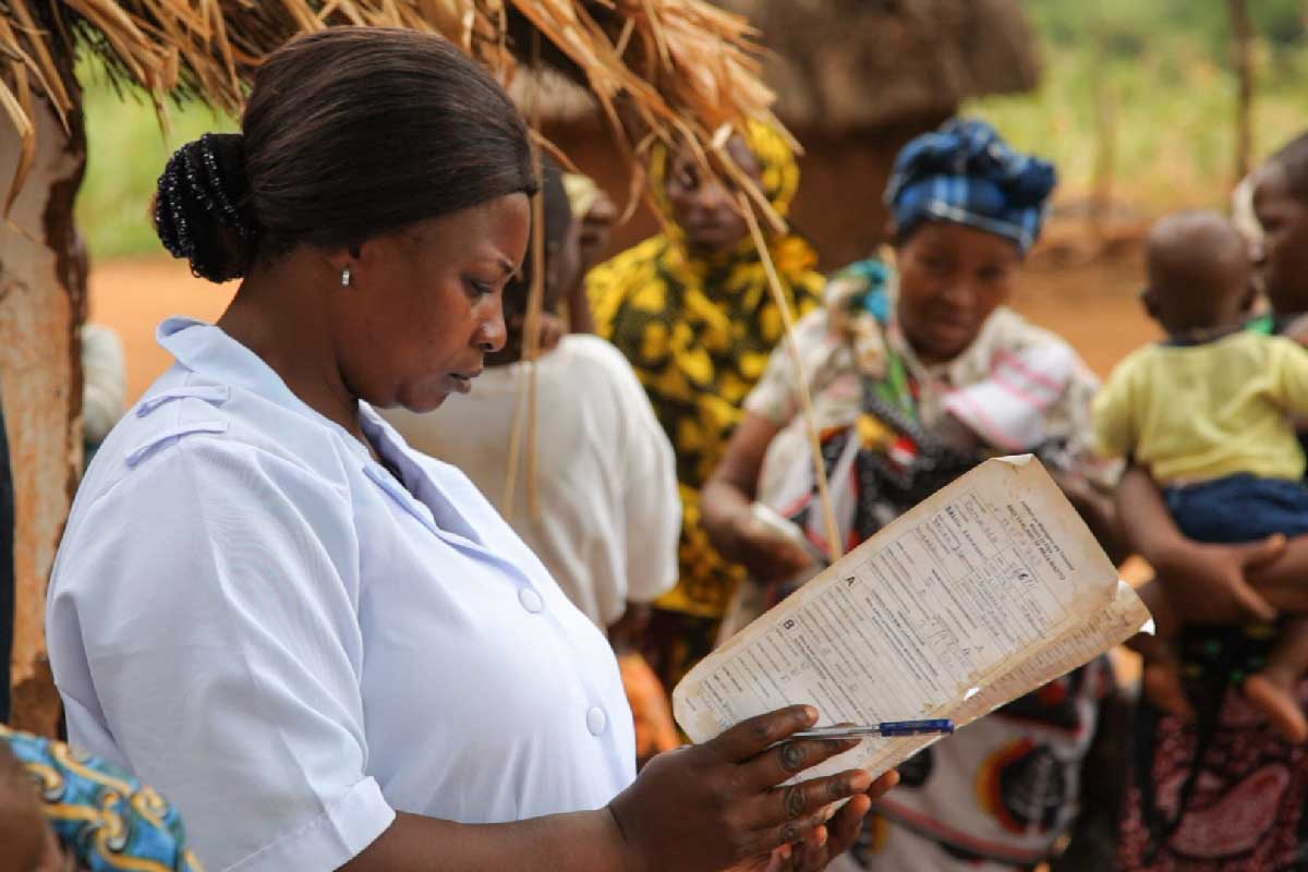 A health worker consults a vaccination sheet