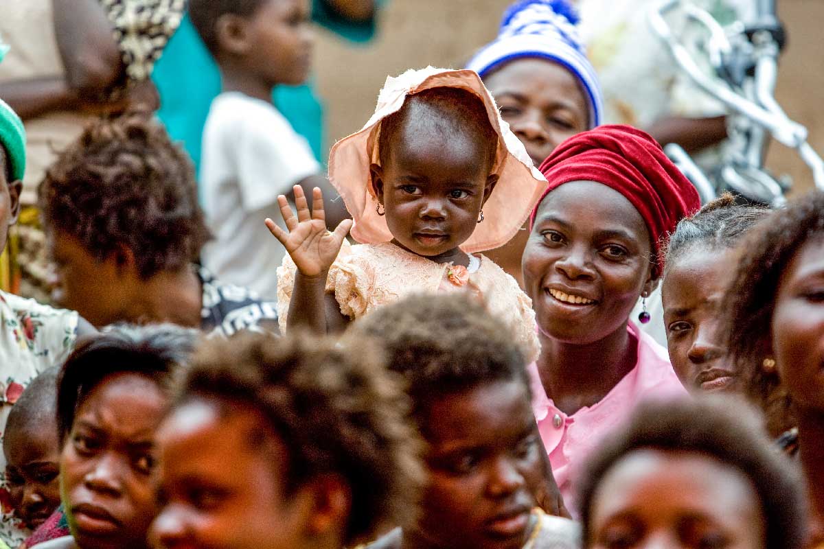 A mother and her child waving amongst a crowd