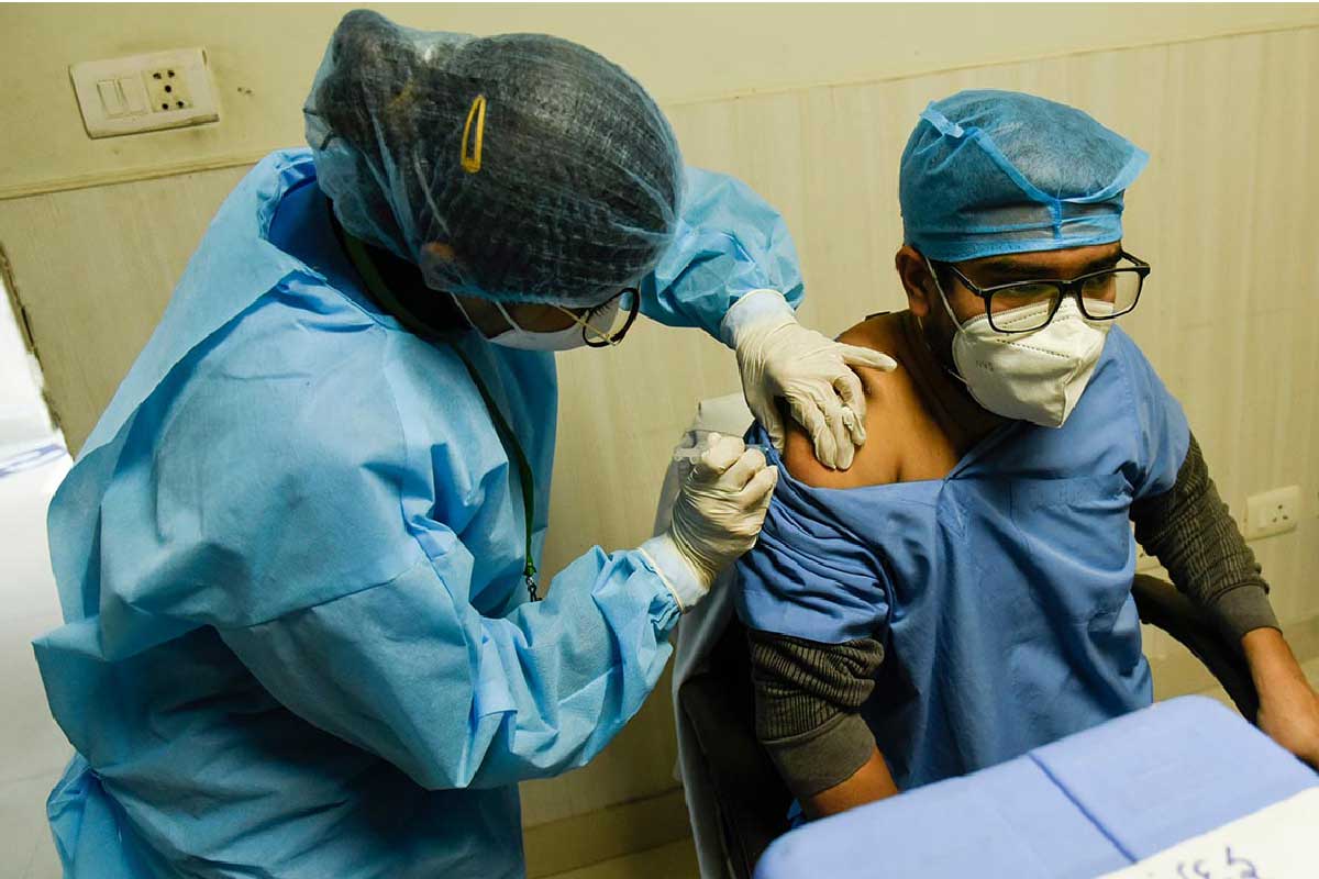 A health worker administering a COVID-19 vaccine